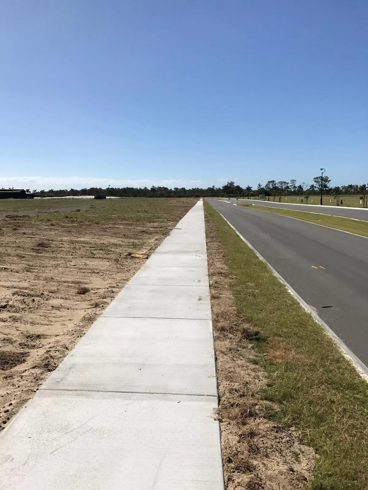 Concrete footpath beside a new estate road