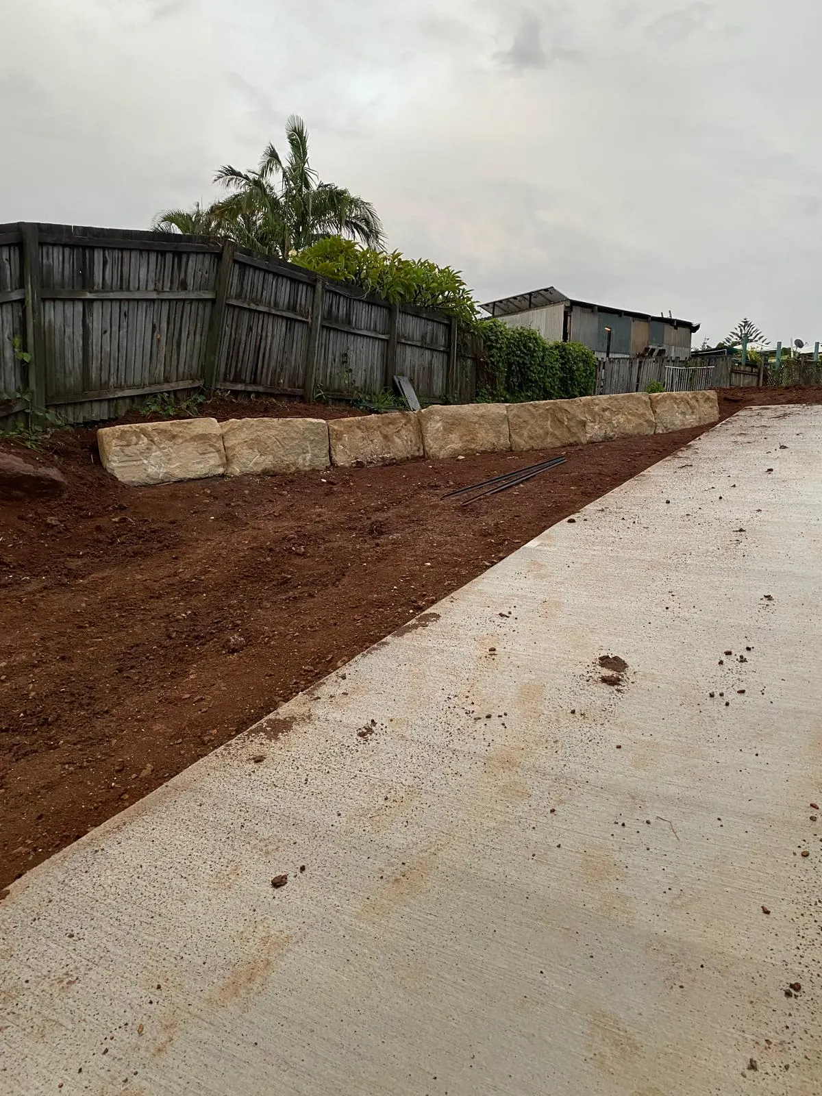 Sandstone wall running beside a new driveway