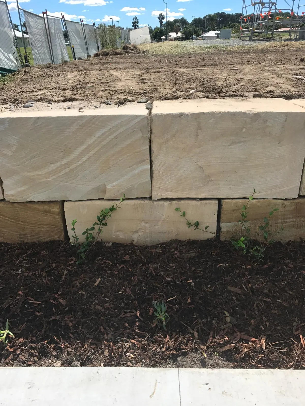 Close view of stacked sandstone blocks above mulch