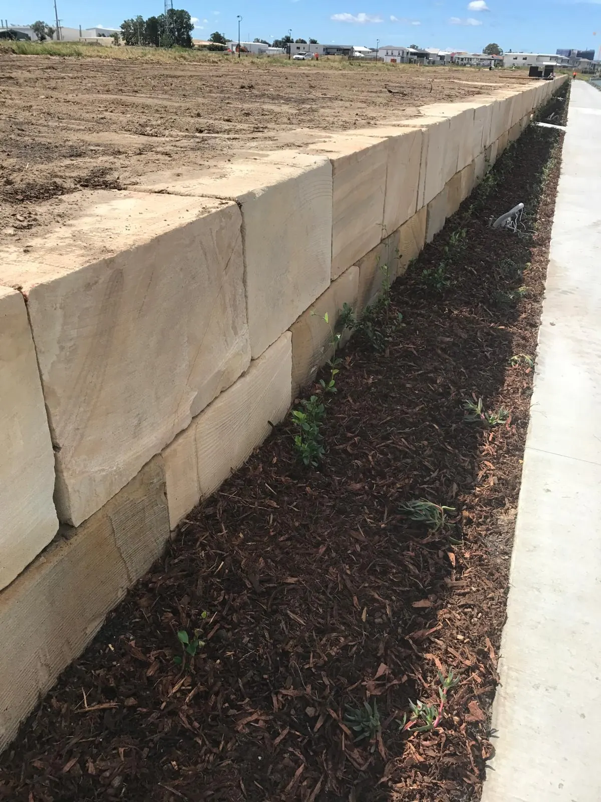 Two courses of sandstone blocks along a path