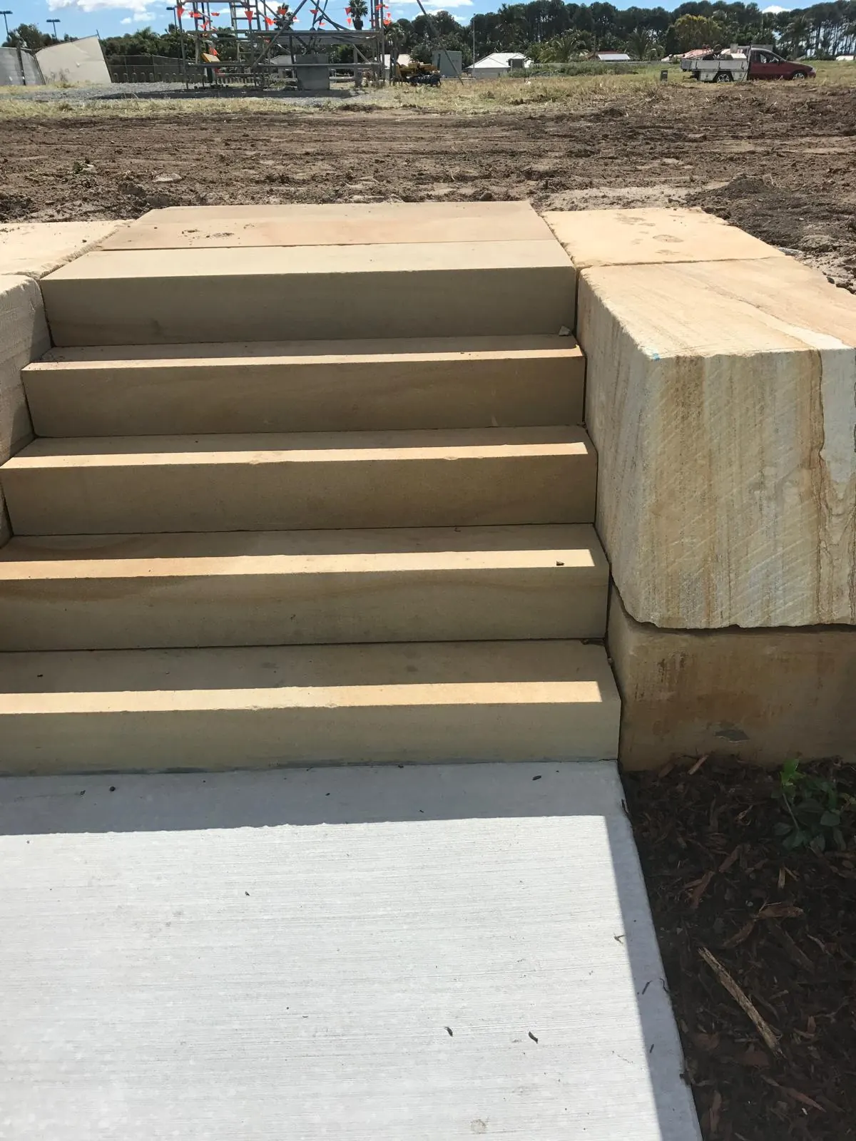 Front view of sandstone steps meeting a concrete landing
