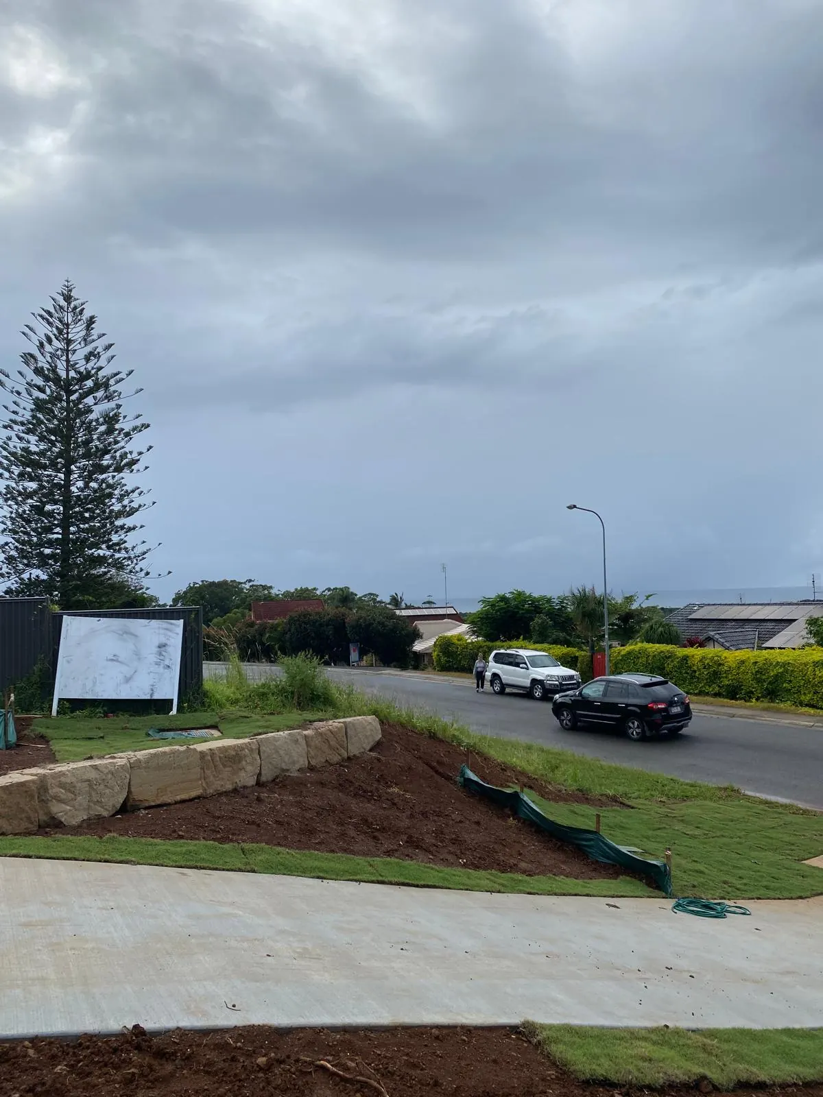 Turf, low sandstone wall and concrete path at the street
